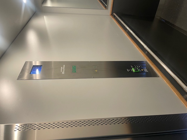 Nyrenoverad hiss med ljusgråa färger och moderna knappar.