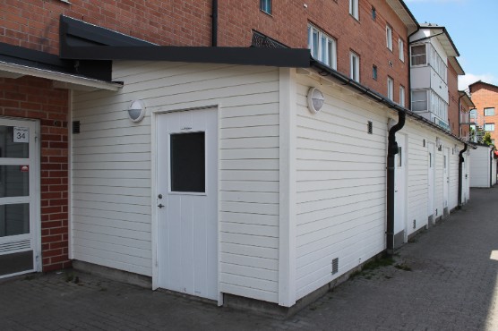 Vitmålad miljöstuga i panel.
