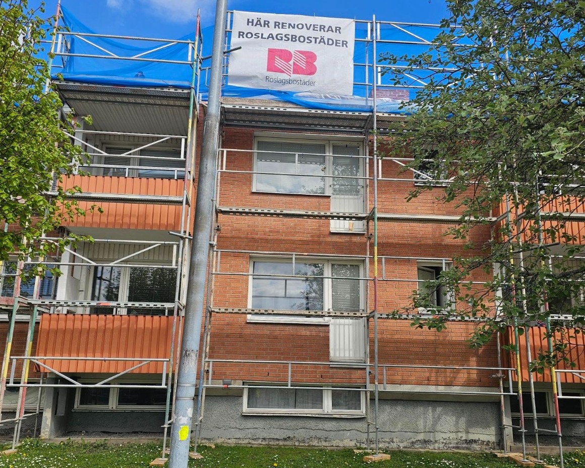 Takrenovering, ett tegelhus med en byggställning.